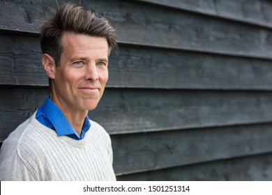 Portrait Shot Of An Attractive, Successful And Happy Middle Aged Man Male Outside Wearing A White Sweater