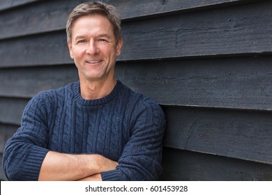 Portrait Shot Of An Attractive, Successful And Happy Middle Aged Man Male Arms Folded Outside Wearing A Blue Sweater