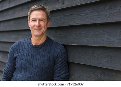 Portrait Shot Of An Attractive, Successful And Happy Smiling Middle Aged Man Male Outside Wearing A Blue Sweater