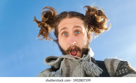 Portrait Shot From Below Of A Funny Young Man With Pigtails Looking At Camera With A Perplexed, Surprised Face And His Mouth Open.