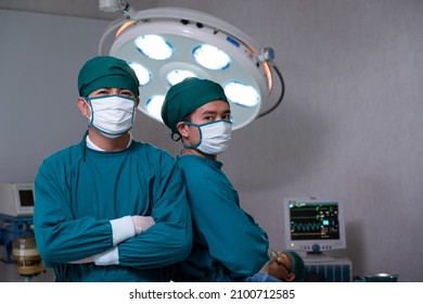Portrait shot of doctor and assistance nurse wearing surgical coat while doing surgical operation for patient inside of the hospital. Medical and professional service occupation.