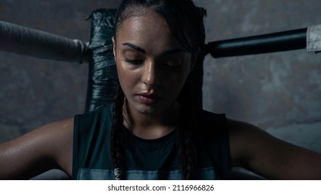 Portrait Shot of an Ethnic Female With Braids Sitting on the Corner of a Boxing Ring Looking Down as She Takes a Break From Sparring Sessions and Training With a Coach. Confident Badass Female Boxer. - Powered by Shutterstock