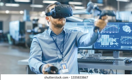 Portrait Shot Of The Industrial Engineer Wearing Virtual Reality Headset And Using Controllers, Ready To Work. In The Background Manufacturing Plant And Monitors.