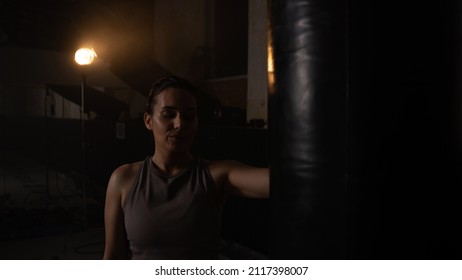 Portrait Shot Of An Isolated Badass Female Fighter On A Black Background Doing A Side Eye, Covered In Sweat As She Is Training Hard In A Boxing Ring Preparing For A Championship.