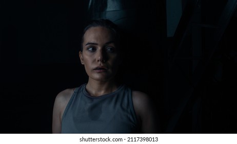 Portrait Shot Of An Isolated Badass Female Fighter On A Black Background Doing A Side Eye, Covered In Sweat As She Is Training Hard In A Boxing Ring Preparing For A Championship.