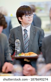 Portrait Shot Of A Middle School Student Walking With His Lunch In The School Cafeteria.