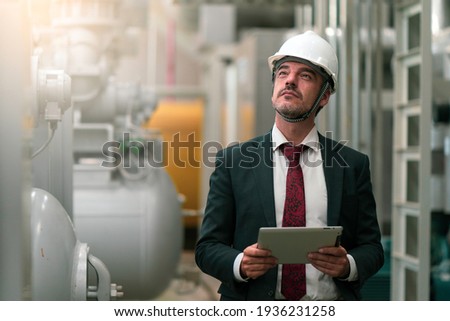 Portrait shot of senior engineer or management inspecting work in the boiler room in factory