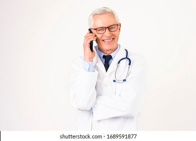 Portrait Shot Of Senior Male Doctor Using Mobile Phone While Talking With His Patient. Isolated White Background.