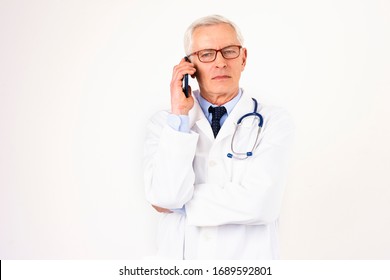 Portrait Shot Of Senior Male Doctor Using Mobile Phone While Talking With His Patient. Isolated White Background.