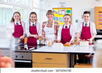 Portrait Shot Of A Teacher And High School Students Cooking In A Home Economics Class.