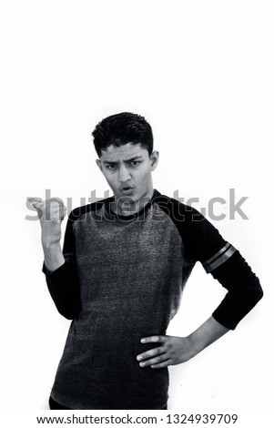 Portrait shot of a teenager wearing black colored full sleeved t-shirt and expressing that he is the superior or boss or master of that job isolated on white.