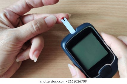 Portrait Showing Glucose Meter Reading Blood Sugar Level Of The Patient Woman, Concept Health Care.