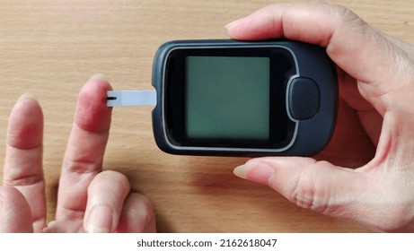 Portrait Showing Glucose Meter Reading Blood Sugar Level Of The Patient Woman, Concept Health Care.