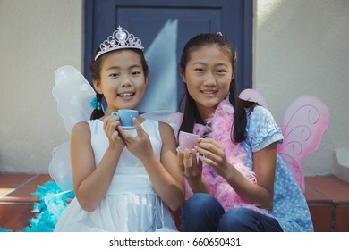 Portrait of siblings in fairy costume having a tea party at home - Powered by Shutterstock