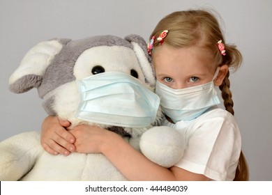 portrait of a sick child in a medical mask with a soft toy - Shutterstock ID 444484039
