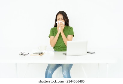 Portrait Of Sick Entrepreneur Asian Woman Got Flu Allergy Sneezing Blowing Wiping Running Nose In Tissue While Working On Pc Laptop Computer In Home Office. Sick Office Worker Concept.