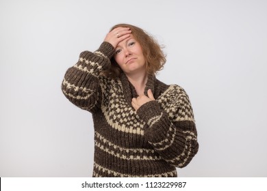 Portrait Of Sick Ill European Female Dressed In Big Wool Brown Sweater. Woman Suffering From Physical Discomfort Because Of Fever. Caucasian Girl Has Fever. She Is Wearing Too Warm Clothes