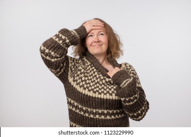 Portrait Of Sick Ill European Female Dressed In Big Wool Brown Sweater. Woman Suffering From Physical Discomfort Because Of Fever. Caucasian Girl Has Fever. She Is Wearing Too Warm Clothes