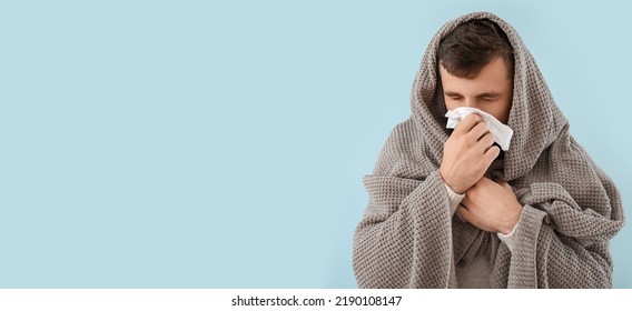 Portrait Of Sick Man With Runny Nose On Light Blue Background With Space For Text