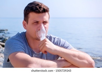 Portrait Sick Man Uses Nebulizer On Seaside. Inhaling Inhaler Mask. Fibrosis Cystic Copd And Treatment Inhaler. Asthma Pulmonary Respiratory Breath Problem And Cure. Painkiller Sedative Gas Oxygen.