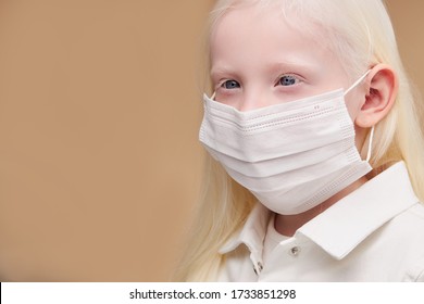 portrait of sick mystic albino child in medical mask isolated, gorgeous girl with absolutely white hair, lashes, eyebrows and blue eyes stand looking side - Powered by Shutterstock