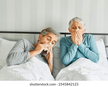 Portrait of a sick senior elderly couple sneezing and using tissue in bed in the morning, a mature woman and man at home, cold or flu illness and pain, senior couple, love and support concept - Powered by Shutterstock