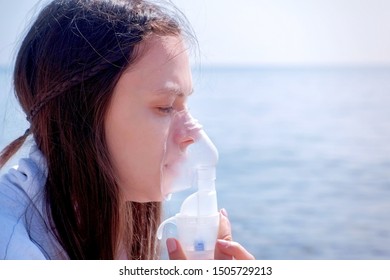 Portrait Sick Woman Use Nebulizer On Seaside. Inhaling Inhaler Mask. Fibrosis Cystic Copd And Treatment Inhaler. Asthma Pulmonary Respiratory Breath Problem And Cure. Painkiller Sedative Gas Oxygen.