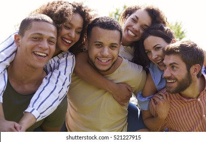 Portrait of six young adult friends piggybacking outdoors - Shutterstock ID 521227915
