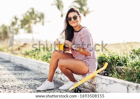 Portrait of skater woman on the beach enjoying a sunny day