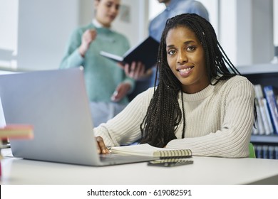 Portrait Of Skilled Afro American Female Copywriter Doing Remote Job Creating Online Project Using Laptop Computer And Wireless Connection, Young International Student Preparing Homework In Library