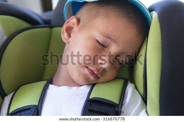 Portrait of a\
sleeping baby in the car\
seat.