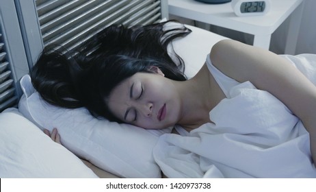 Portrait Of Sleeping Woman Having Nightmares Lying In Comfort Warm White Bed Cover By Blanket. Beautiful Asian Female Frowning Sleep In Midnight At Home. Bad Quality Of Restless Young People.