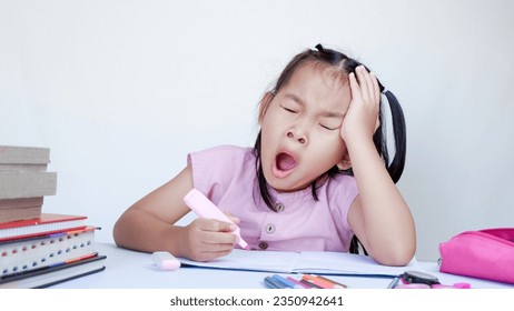 Portrait Of Sleepy Little Asian Female Child At Desk Tired After Doing School Homework. - Powered by Shutterstock