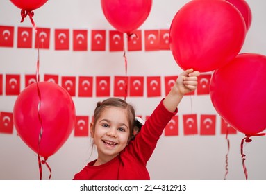 Portrait of small baby girl with Turkish flag. Cute little child celebrating Turkish National Sovereignty and Children's Day or Commemoration of Atatürk Youth and Sports Day. Red white colors concept.