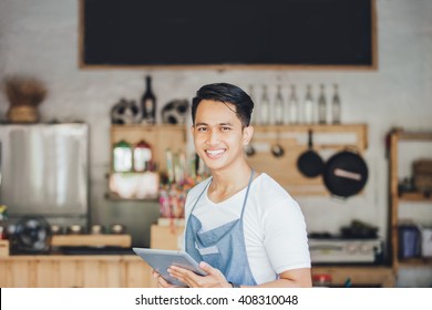 portrait of small business owner at his coffee shop using tablet pc - Shutterstock ID 408310048