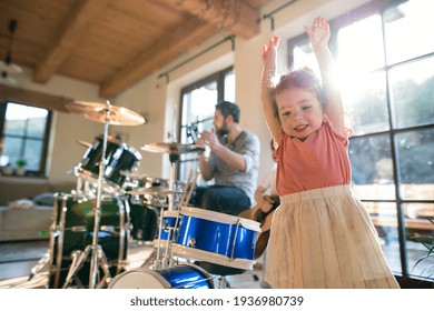 Portrait Of Small Children With Father Indoors At Home, Playing Drums.