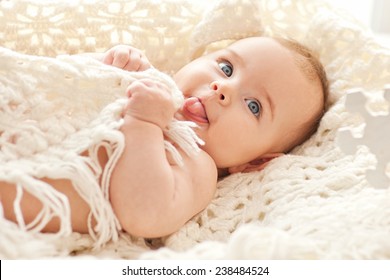 Portrait of small cute girl with blue eyes in her cozy white bed. - Powered by Shutterstock