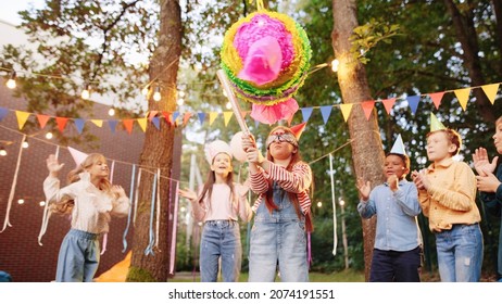 Portrait of small girl smash a pi–ata with a bat with friends and presents outdoors in garden in summer. Happy birthday concept - Powered by Shutterstock