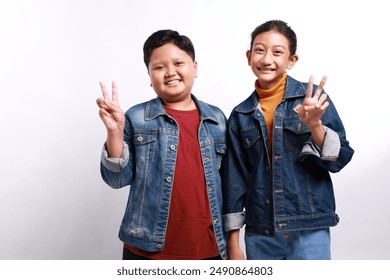 Portrait of small little trendy cheerful friends friendship hugging showing v-sign isolated over white background - Powered by Shutterstock