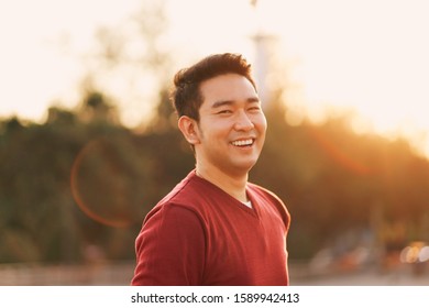 Portrait smart Asian man under the warm light in nature park. - Powered by Shutterstock