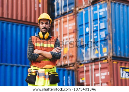 Portrait smart creative foreman engineer man wear safety helmet standing arms cross and looking camera. Logistic, transportation, import and export concept with copy space.