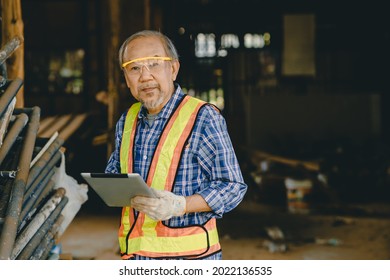 Portrait Smart elder engineer worker foreman using tablet computer technology at construction site.