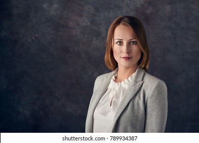 Portrait Of Smart Elegant Woman Standing Against Dark Background