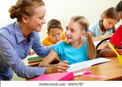 Portrait smart girl   her teacher looking at each other at lesson in classroom