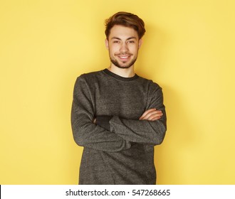 Portrait of a smart  young man standing against yellow backgroun