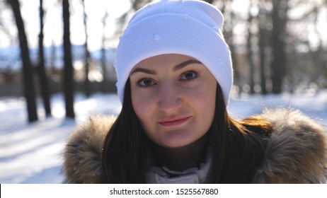 Portrait Of Smile Woman Walking And Admiring Beautiful Winter Landscapes. Carefree Cute Girl Going Through Winter Forest Looking Around. Lady Having Stroll At Sunny Winter Day. Winter Concept. Slow Mo