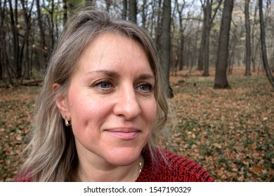 Portrait Of Smiled Mature Woman In Autumn Forest. Girl Does Not Look At Camera On Blurred Background. Thought, Meditation Or Doubt Expression. Relax Or Other Mental Psychology Concept