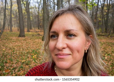 Portrait Of Smiled Mature Woman In Autumn Forest. Girl Does Not Look At Camera On Blurred Background. Thought, Meditation Or Doubt Expression. Relax Or Other Mental Psychology Concept