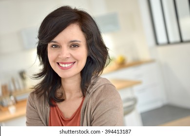 Portrait of smiling 40-year-old woman at home - Shutterstock ID 394413187