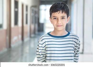 Portrait Of Smiling 6-7 Years Indian Kid, Standing Straight At School Campus In School Uniform And Looking At Camera